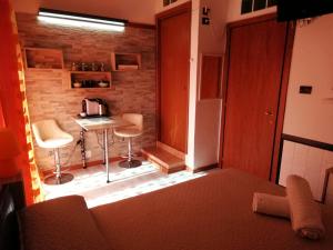 Habitación pequeña con cocina con mesa y sillas. en B&B Alghero Republic en Alghero