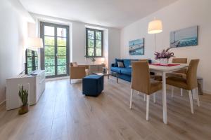 un soggiorno con tavolo e divano blu di Residence La Torre a Trieste