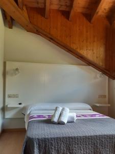 a bedroom with a bed with two towels on it at Hotel Puente Vidosa in Amieva