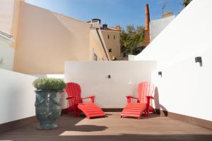 - deux chaises rouges et un vase sur le balcon dans l'établissement Hermitage Castelo - Casa Saint Jorge, à Lisbonne