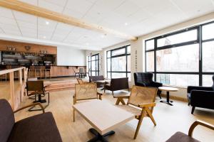 a waiting room with chairs and tables and windows at Village Vacances le Bérouze in Samoëns