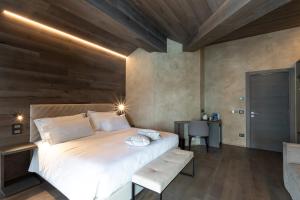 a bedroom with a large bed with a wooden wall at Bergman Mountain Hotel in Breuil-Cervinia