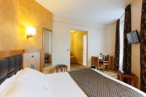 a hotel room with a bed and a desk at Hotel Bellevue Saint-Lazare in Paris