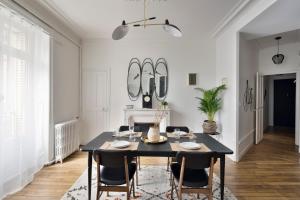 une salle à manger avec une table et des chaises noires dans l'établissement Le Contour Saint-Aubin - Inspiration Art Déco en cœur de Ville, à Rennes