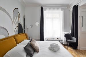 una camera da letto con un letto e due asciugamani di Le Contour Saint-Aubin - Inspiration Art Déco en cœur de Ville a Rennes