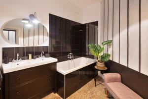 a bathroom with a sink and a tub and a mirror at Le Contour Saint-Aubin - Inspiration Art Déco en cœur de Ville in Rennes