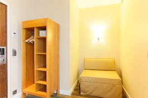 a small room with a bed and a book shelf at Hotel Bellevue Saint-Lazare in Paris
