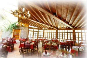 a dining room with tables and chairs and chandeliers at Hotel Puente Vidosa in Amieva