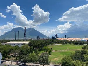 a view of a power plant with a mountain in the background at Hotel Hi! Fundidora in Monterrey