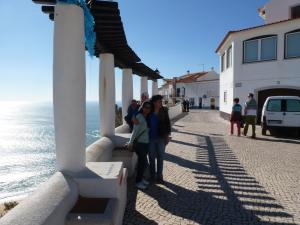 a group of people standing on a sidewalk near the ocean at Casa Bianca in Caldas da Rainha