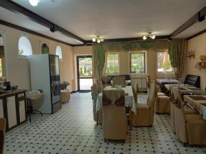 a restaurant with tables and chairs in a room at Guest House Stary Zamok in Kislovodsk