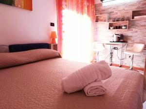 Un dormitorio con una cama con una toalla. en B&B Alghero Republic, en Alghero