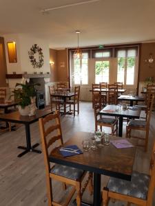 a dining room with wooden tables and chairs at Hôtel Restaurant "Adultes Uniquement - Adults Only" Le Moulin de la Renne proche Zoo de Beauval in Thésée