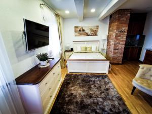 een slaapkamer met een bed en een flatscreen-tv bij Lavender Inn Guest House in Viešvėnai
