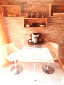 a kitchen with a table and two chairs and a tea kettle at B&B Alghero Republic in Alghero