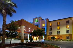 a hotel exterior at night with palm trees at Holiday Inn Express Hotel & Suites Cocoa Beach, an IHG Hotel in Cocoa Beach