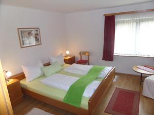 a bedroom with a bed with a green blanket on it at Gästehaus Verena in Mondsee