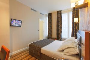a hotel room with a bed and a window at Hotel Bellevue Saint-Lazare in Paris