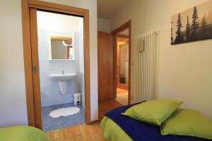ein Schlafzimmer mit einem Bett und ein Badezimmer mit einem Waschbecken in der Unterkunft Haus Martina by ISA AGENTUR in Bad Kleinkirchheim