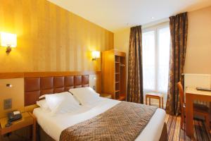 a hotel room with a bed and a window at Hotel Bellevue Saint-Lazare in Paris