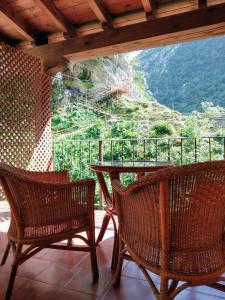 a porch with two chairs and a table with a view at Apartamentos Aguasaliu in Ponga
