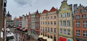 a group of buildings in a city with people walking at Patio Apartments - Old Town in Gdańsk