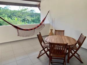 a hammock in a room with a table and chairs at L OREE DU BOIS in Cayenne