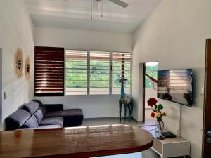 a living room with a couch and a table at L OREE DU BOIS in Cayenne