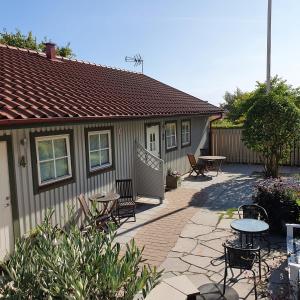 a patio with tables and chairs and a house at B&B Villa Orion in Sölvesborg