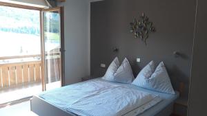 ein Bett mit weißer Bettwäsche und Kissen in einem Schlafzimmer in der Unterkunft Haus Rohr in Weissensee