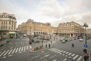 a busy city street with a crosswalk in front of buildings at Hotel Bellevue Saint-Lazare in Paris