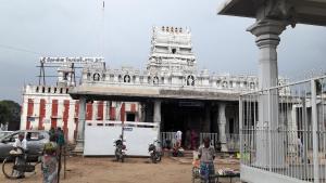 un gran edificio blanco con gente parada frente a él en Hotel Mayas, en Tiruchchirāppalli