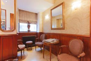 a waiting room with chairs and a table and mirrors at Hotel Bellevue Saint-Lazare in Paris