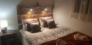 Schlafzimmer mit einem Bett mit einem Kopfteil aus Holz und Kissen in der Unterkunft Dolina Rosy in Ustrzyki Dolne