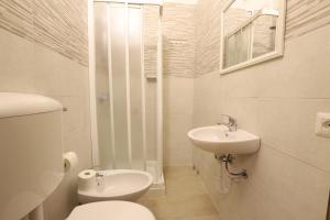 La salle de bains blanche est pourvue de toilettes et d'un lavabo. dans l'établissement Carlo Goldoni Hotel, à Milan