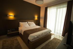 a bedroom with a bed and a large window at Gente Apartments in Cluj-Napoca