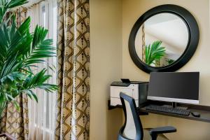 a desk with a computer and a mirror at Candlewood Suites - Orlando - Lake Buena Vista, an IHG Hotel in Orlando