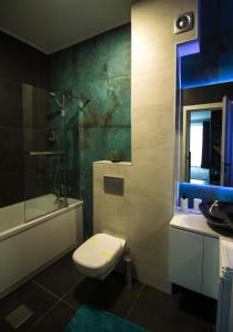 a bathroom with a toilet and a shower and a sink at Gente Apartments in Cluj-Napoca +18 photos