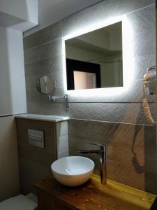 La salle de bains est pourvue d'un lavabo blanc et d'un miroir. dans l'établissement Hostal Canton Plaza, à Hospital de Órbigo