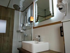 bagno con lavandino bianco e specchio di Hostal Canton Plaza a Hospital de Órbigo