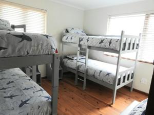 a bedroom with two bunk beds and a window at 5 Dune Park in Keurboomstrand