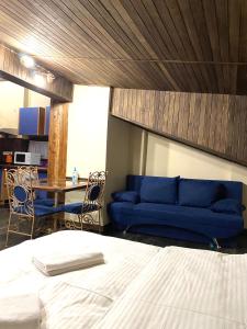 ein Wohnzimmer mit einem blauen Sofa und einem Tisch in der Unterkunft Квартира в центрі на вулиці Лесі Українки 19 in Lwiw