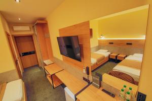 a hotel room with two beds and a flat screen tv at Sport Hotel 1 in Cherkasy