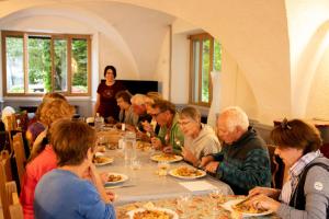 a group of people sitting at a table eating food at Gîte Les Bartavelles in Jausiers +49 photos