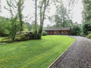 a small cabin in the middle of a grassy yard at Millmore Cabin in Killin