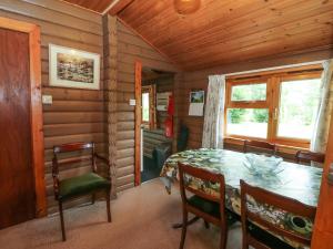 a dining room with a table and chairs in a cabin at Millmore Cabin in Killin