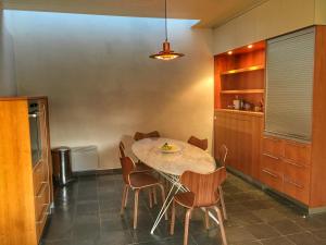 a kitchen with a table and chairs in a room at Villa Amoulogies in Amougies