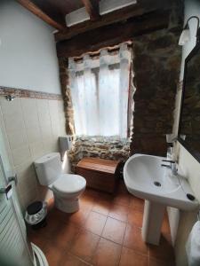 a bathroom with a sink and a toilet and a window at Casa Rural Irigoien in Donostia-San Sebastián