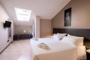 a bedroom with a large white bed and a television at Hotel Duomo Cremona in Cremona