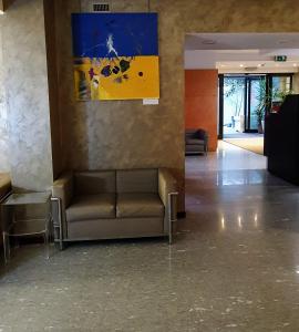 una sala d'attesa con divano e un dipinto sul muro di Hotel Metrò a Milano